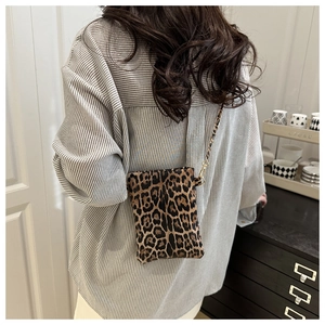 Detailed close-up of leopard print crossbody bag with black and gold chain strap
