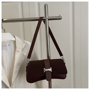 Detail einer dunkelbraunen Baguette-Tasche mit silberner Schnalle und mattem Leder-Finish