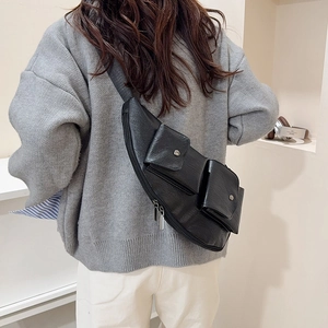 Chic black faux leather chest bag with dual pockets and textured finish on a model back
