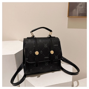 Close-up of black lychee texture backpack with rabbit prints and gold metal buckles