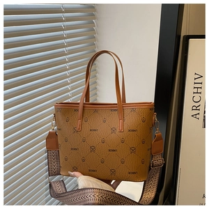 Detail of vintage printed tote bag with cat patterns and woven brown shoulder strap