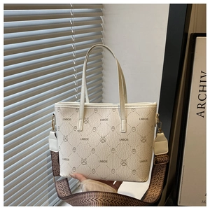 Detail of white tote bag with bear jacquard and wide geometric textured shoulder strap