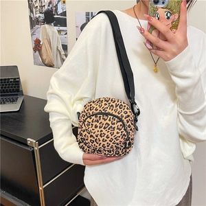 Fashionable leopard print crossbody bag with dual zippers and adjustable black strap