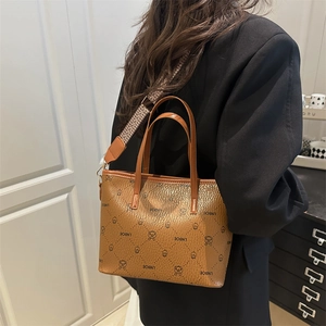 Brown leather tote bag with cartoon print and wide patterned shoulder strap