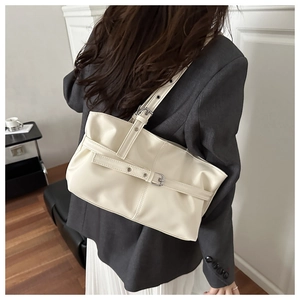 Vue détaillée du sac cabas crème avec sangles à boucle métallique sur modèle
