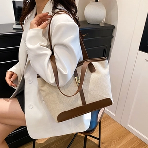 Minimalist canvas bucket tote bag with brown leather trim and metal hardware detail