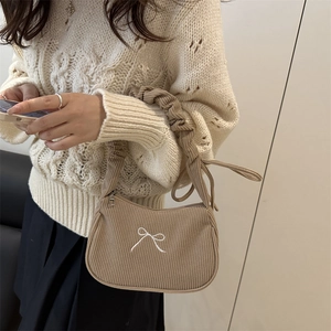 Sac bandoulière en velours côtelé kaki avec broderie nœud et bandoulière plissée sur pull