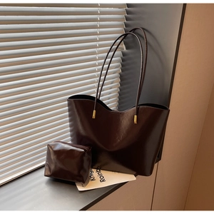 Detail view of the deep brown leather tote and matching small zippered pouch set