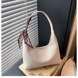 Détail du sac bandoulière blanc cassé avec grain de galet et foulard en soie décoratif