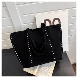 Détail des rivets argentés sur le sac cabas noir en daim avec bandoulière rétro
