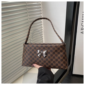 Close-up of brown printed leather shoulder bag with a silver metal butterfly detail