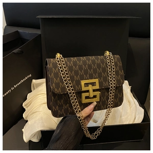 Détail du sac carré vintage avec imprimé M dans une boîte cadeau avec chaîne dorée