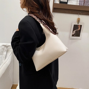 Sac sous le bras minimaliste en cuir grainé beige avec un foulard en soie décoratif
