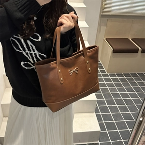 Brown PU leather tote bag with gold bow clasp and rivets for elegant commuting style