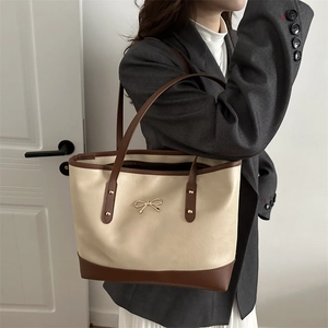 Minimalist PU leather tote bag with contrast trim and golden bow buckle on model