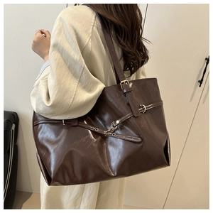 Close-up of the vintage dark brown tote bag showing textured PU leather and gold buckles