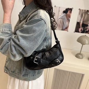 Chic black crescent underarm bag with vintage buckle straps on a casual denim look