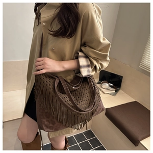 Detail of dark brown crochet tote bag with mesh texture and long tassel fringe trim