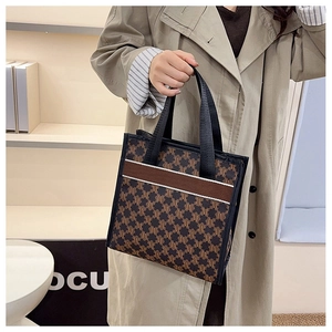 Detailed close-up of large-capacity tote bag with brown monogram pattern and woven handles
