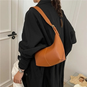 Chic caramel brown dumpling bag in lychee leather featuring a half-moon shape design