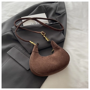 Détail du sac hobo en daim marron avec bandoulière réglable et ferrures dorées