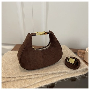 Détail du sac croissant en daim montrant la boucle dorée et le tissu brun texturé