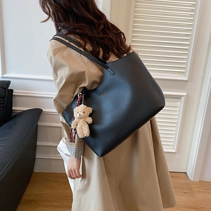 Classic black leather tote bag with large capacity and cute plush bear charm decoration