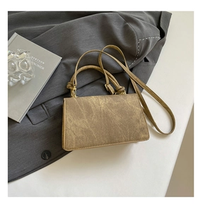 Detail of vintage gradient bronze handbag with knot handle and antique texture