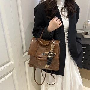 Vintage brown waxed leather backpack with turn-lock closure and cute rabbit charm detail
