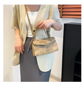 Detail of vintage bronze crossbody bag with unique knot handle and metallic gradient finish