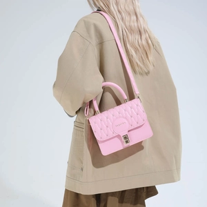 Pink quilted crossbody bag with adjustable strap and golden fashion logo on top handle