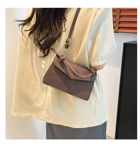 Detail of vintage brown leather handbag with knot handle and adjustable strap