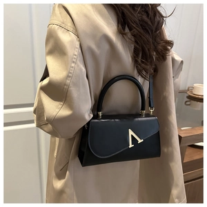 Chic black matte evening clutch featuring a minimalist gold V-shaped buckle and top handle