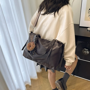 Retro deep brown faux leather tote bag with wide strap and plush donut charm accessory