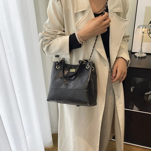 Elegante borsa a secchiello trapuntata nera con catena d'oro e chiusura girevole