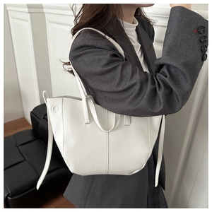 Close-up of white lychee grain leather tote bag worn by model for daily commute style