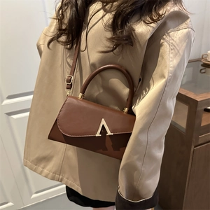 Elegant brown leather evening clutch with gold V-hardware and adjustable crossbody strap