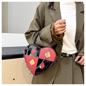 Detail of heart-shaped handbag with red and black checkered pattern and poker suits