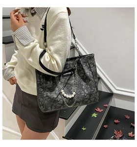 Detail of grey floral tote bag with large white pearls and silver metal chain strap