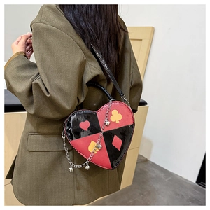 Close-up of heart-shaped handbag featuring poker suits print and metallic chain detail