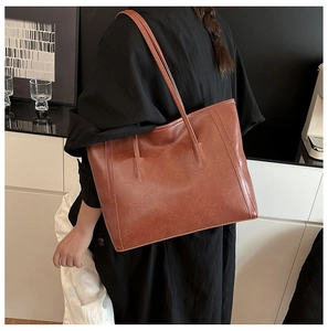 Borsa tote in pelle sintetica marrone con spalline lunghe mostrata su una modella
