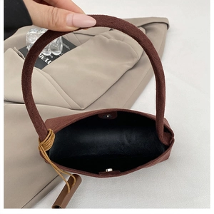 Détail du sac bandoulière en daim marron avec fermoir magnétique et doublure interne