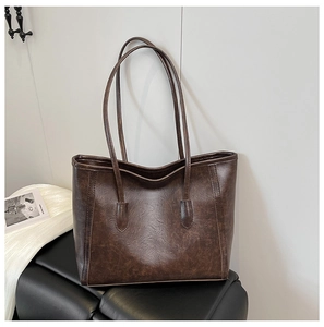 Dettaglio della borsa tote marrone scuro con trama a rughe naturali e finitura in pelle cerata