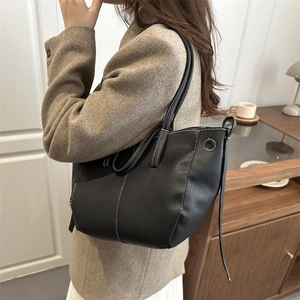 Elegant black tote bag with white contrast stitching and soft pebbled leather finish