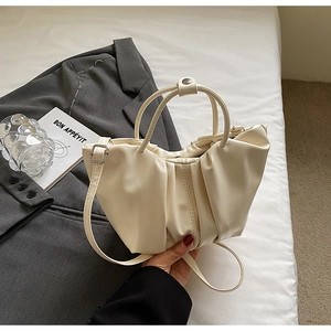 Détail du sac nuage plissé minimaliste en similicuir blanc cassé avec fermoir métallique