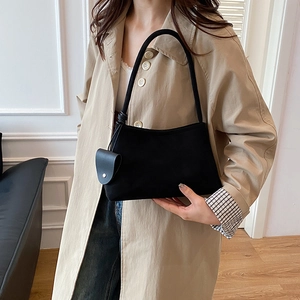Sac bandoulière noir mat rétro avec pendentif cœur porté par un mannequin chic