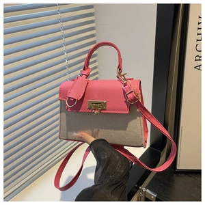 Detail shot of the contrast pink leather flap and beige canvas fabric texture of the handbag
