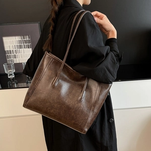 Borsa tote retrò in pelle marrone scuro con trama cerata indossata da una modella