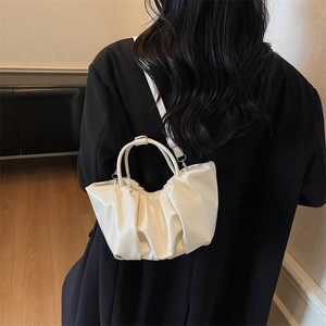 Sac nuage plissé blanc en similicuir porté élégamment sur une veste de blazer noire