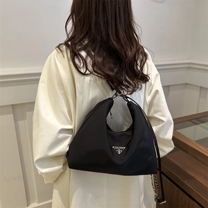 Versatile black hobo travel backpack and crossbody bag with iconic metal logo plaque
